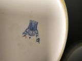 a close up of a white and blue vase with a bird on it