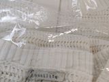 a white sweater with a label on it sitting on a table