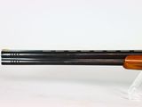 a close up of a rifle on a stand on a white surface