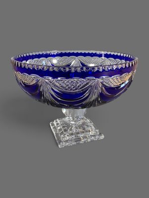 un bol en verre bleu posé sur un socle transparent