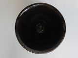 a close up of a black vase on a white surface