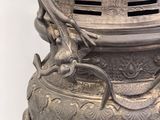 a large silver vase with a dragon on it