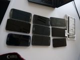 Plusieurs téléphones portables sont posés sur une table à côté d'un ordinateur portable