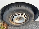 a white van with a flat tire on the side of the road