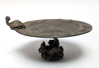 a metal tray with a bird on top of it