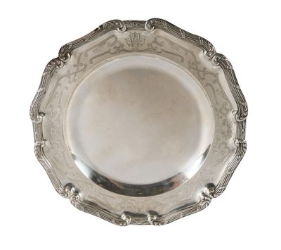 une assiette ancienne en argent, ornée d'un motif décoratif sur fond blanc