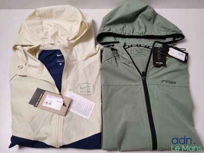 deux vestes pour homme, munies d'une capuche et d'étiquettes, posées l'une à côté de l'autre