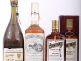 plusieurs bouteilles d'alcool sont alignées sur une surface blanche
