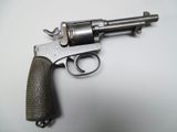 an old gun is sitting on a white surface with a black handle