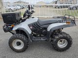 une photo d'un quad argenté garé sur un parking