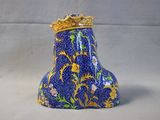 a blue vase with a gold crown on top of it