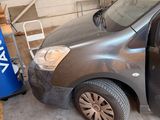 a van that is parked in a garage with a trash can