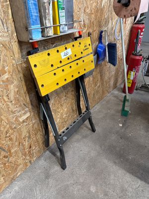 un établi jaune sur lequel sont posés des outils, dans un garage