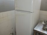 a white refrigerator in the corner of a kitchen