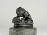 a bronze statue of a lion on a marble base