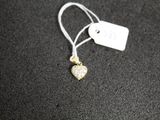 un petit pendentif en forme de cœur doré sur un fond noir