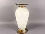 a white vase with a gold rim sitting on a table