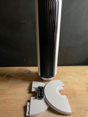 a fan that is sitting on a table next to a remote control