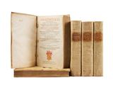 three old books sitting on top of a wooden shelf next to each other