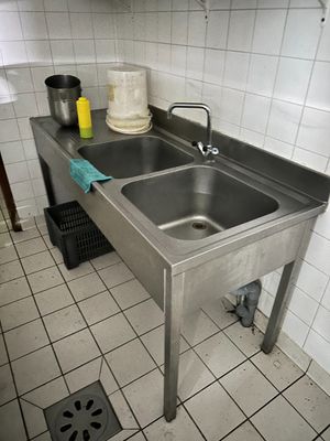 un évier en acier inoxydable dans une cuisine équipée d'un siphon