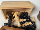 a wooden box filled with chess pieces on a white surface