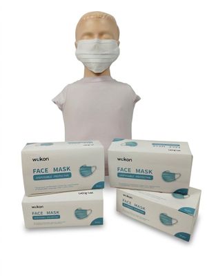 trois boîtes de masques faciaux et une tête de mannequin sur fond blanc