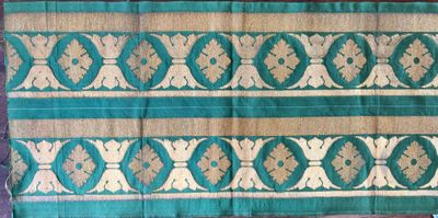 an image of a green and gold cloth with a design on it
