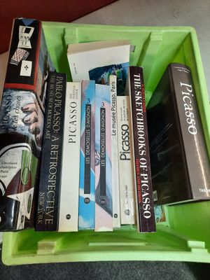 many books in a green box on a table