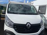 La camionnette blanche est garée à côté de la remorque sur le parking.