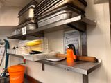 a metal shelf that has pots and pans on it