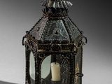 an old fashioned lantern with a candle inside of it on a table