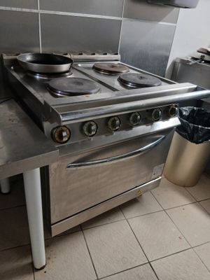 une cuisinière avec une casserole dessus, dans une cuisine