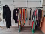 a lot of clothes hanging on a rack in a room