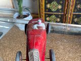 a red toy car that is sitting on a glass table