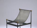 un fauteuil de salon noir et doré, doté d'une structure et de pieds en métal