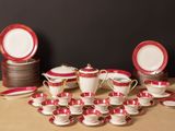 a lot of red and white dishes and cups on the table