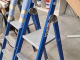 three ladders that are sitting in a room