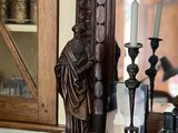 a statue of a man sitting on a mantle next to a mirror