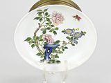 a white plate with a blue vase and flowers on it