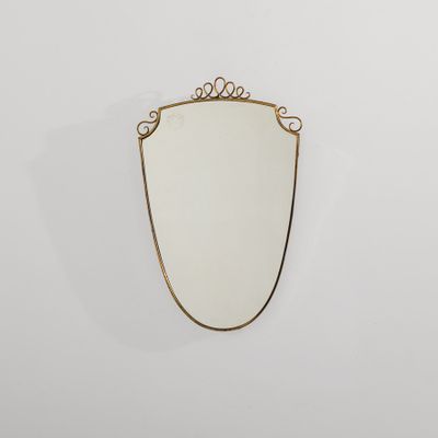 un miroir à cadre doré accroché à un mur blanc