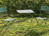 two chairs and a table on the grass in the yard