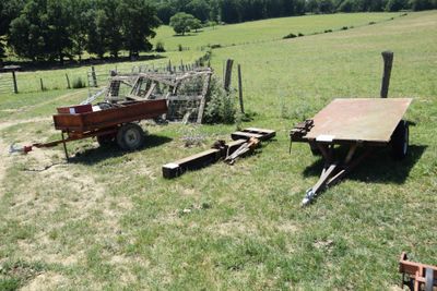 a red trailer and a red wagon in a field