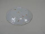 a white plate that has some brown spots on it