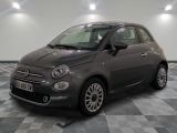 La petite voiture grise est garée dans le garage, sur le sol à damier.