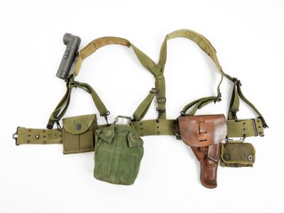 two holsters are hanging on a wall with one holding a gun