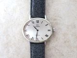 une montre en argent avec des chiffres romains, montée sur un bracelet en cuir noir