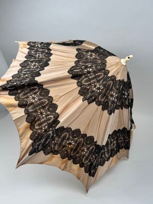 un parapluie ouvert orné de dentelle noire sur fond blanc
