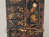 a black and gold chest of drawers with a clock on top