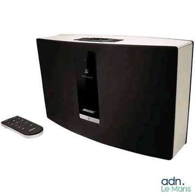 une image représentant une enceinte en noir et blanc avec une télécommande