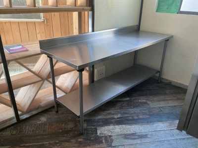 a stainless steel work table in the corner of a room